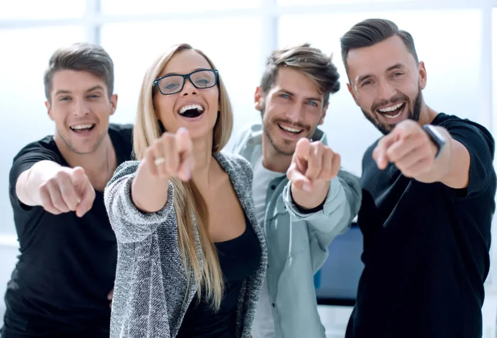 osteopathie düsseldorf erwachsene 1 Osteopathie für Erwachsene: Vier lachende Menschen, die mit dem Finger nach vorne zeigen.